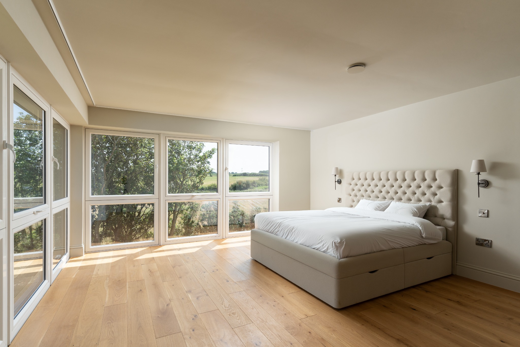 Bedroom with wraparound glazing and landscape views