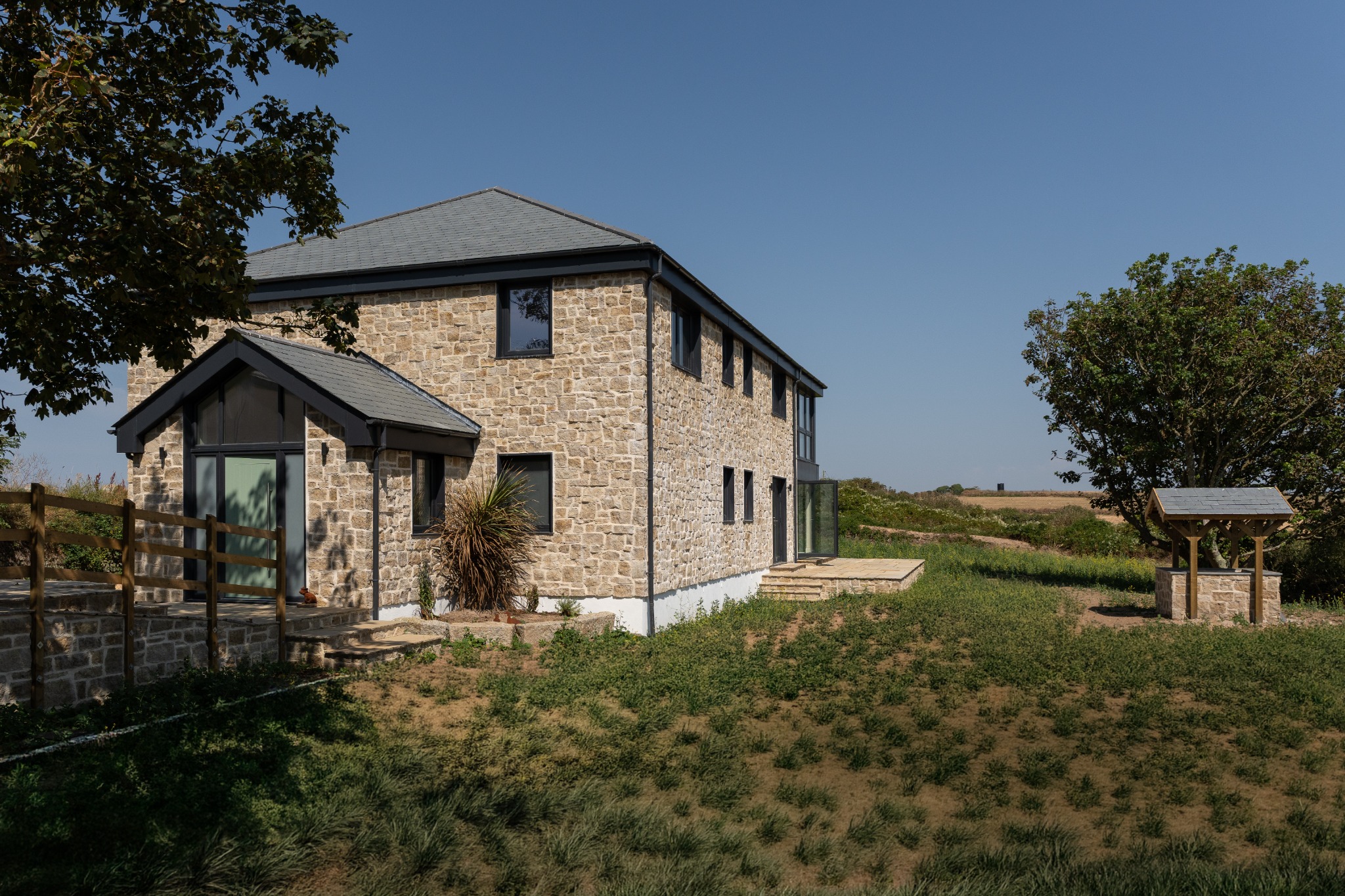 Parc Carn built in local stone within a natural coastal landscape