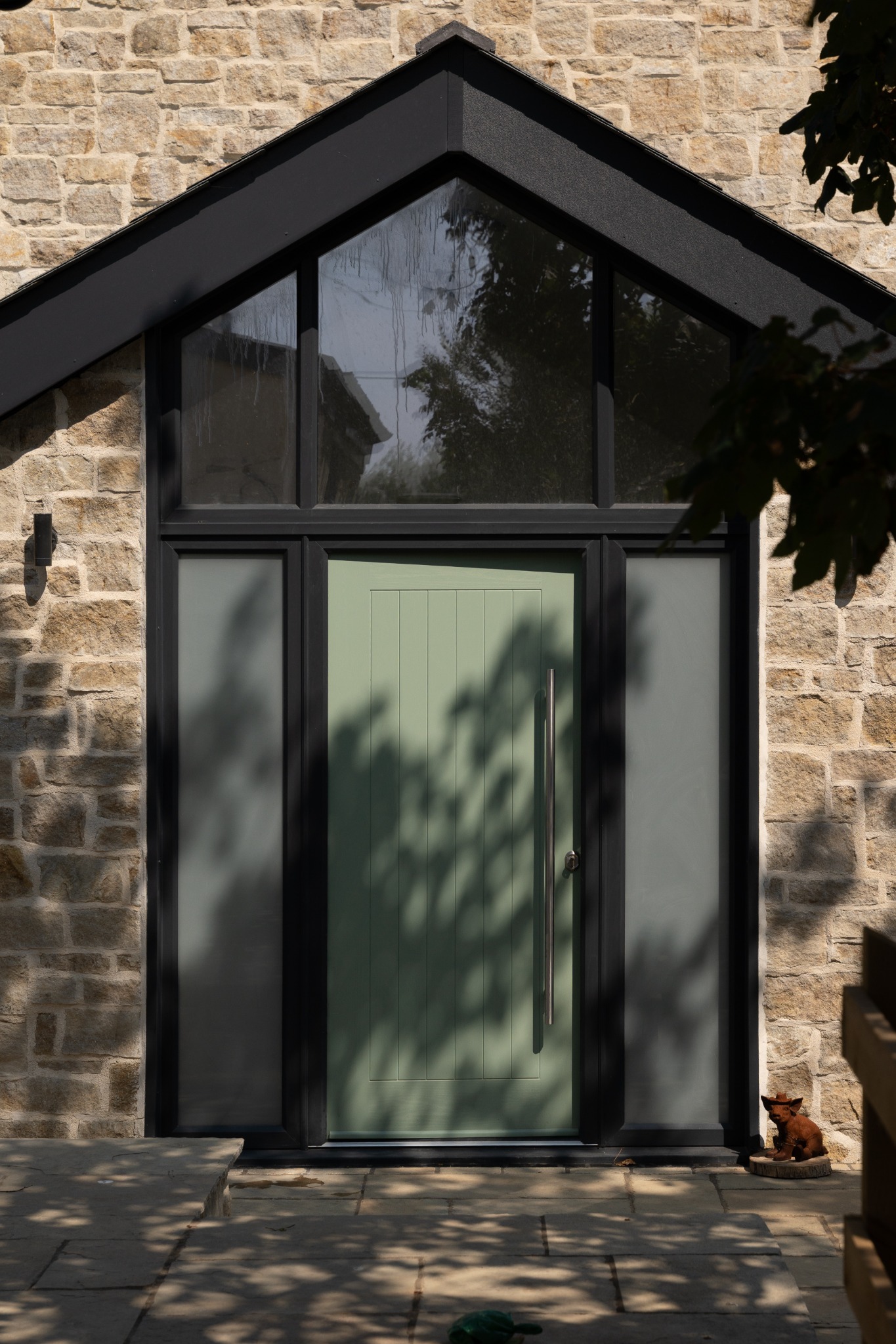 Glazed gable entrance framed by stone walls