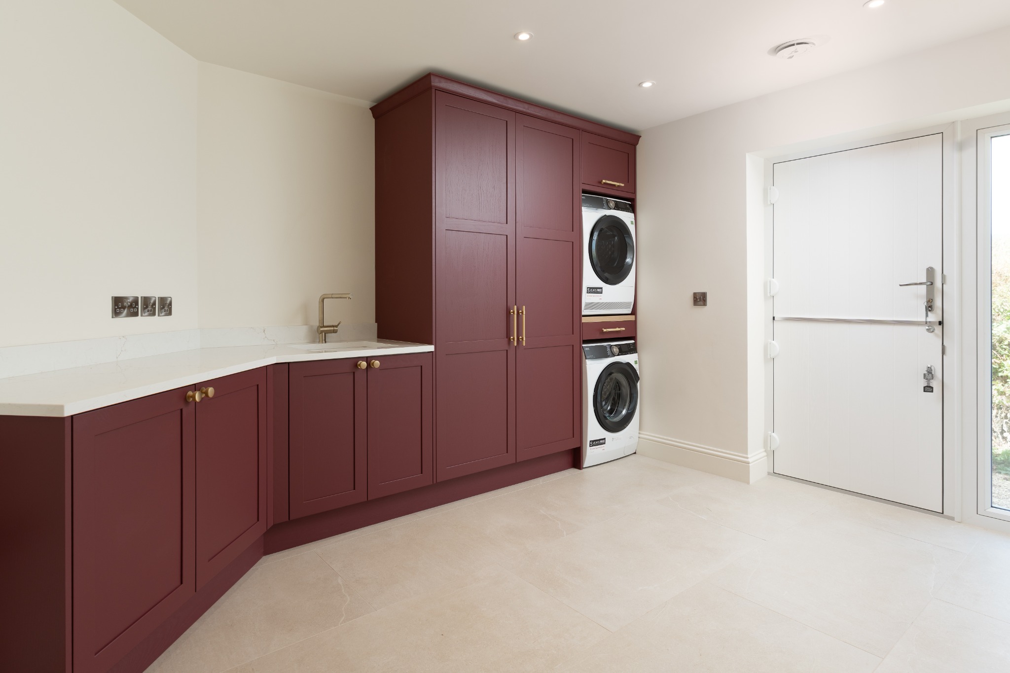 Utility room with deep red cabinetry