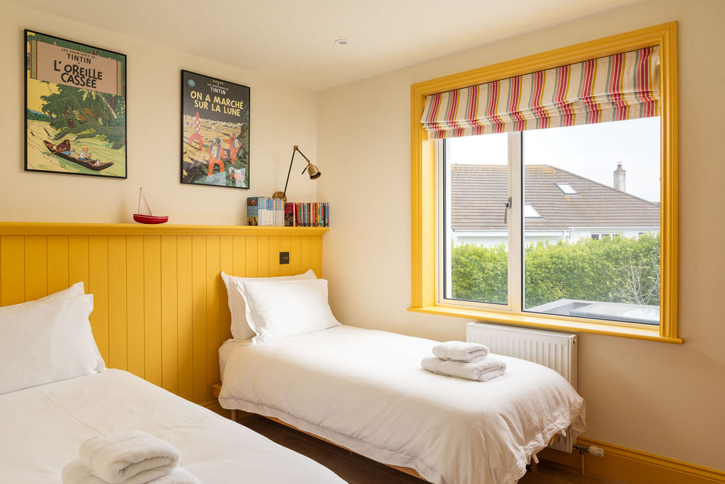 Twin bedroom with yellow panelled headboards