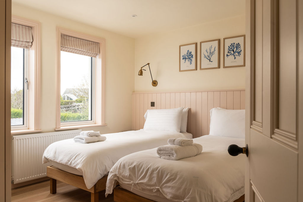 Twin bedroom with soft pink panelled headboards