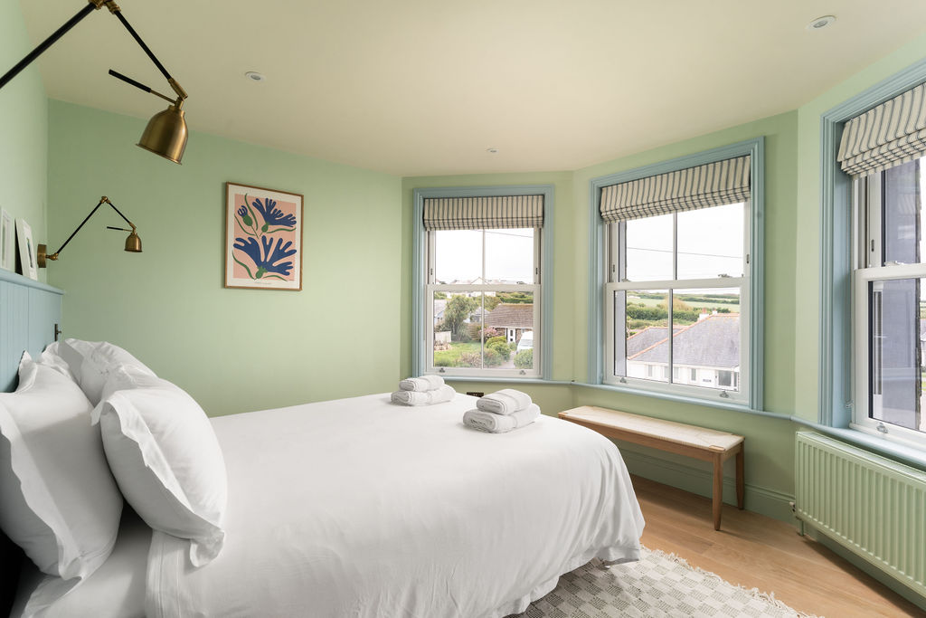 Principal bedroom with three windows and green walls