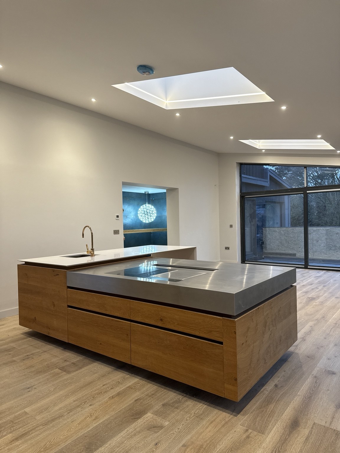 Timber kitchen islands beneath rooflights at Little Bodieve