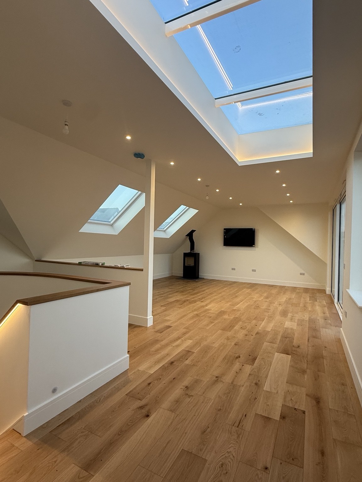 Upper-floor living space with timber flooring and rooflights at Sandoways