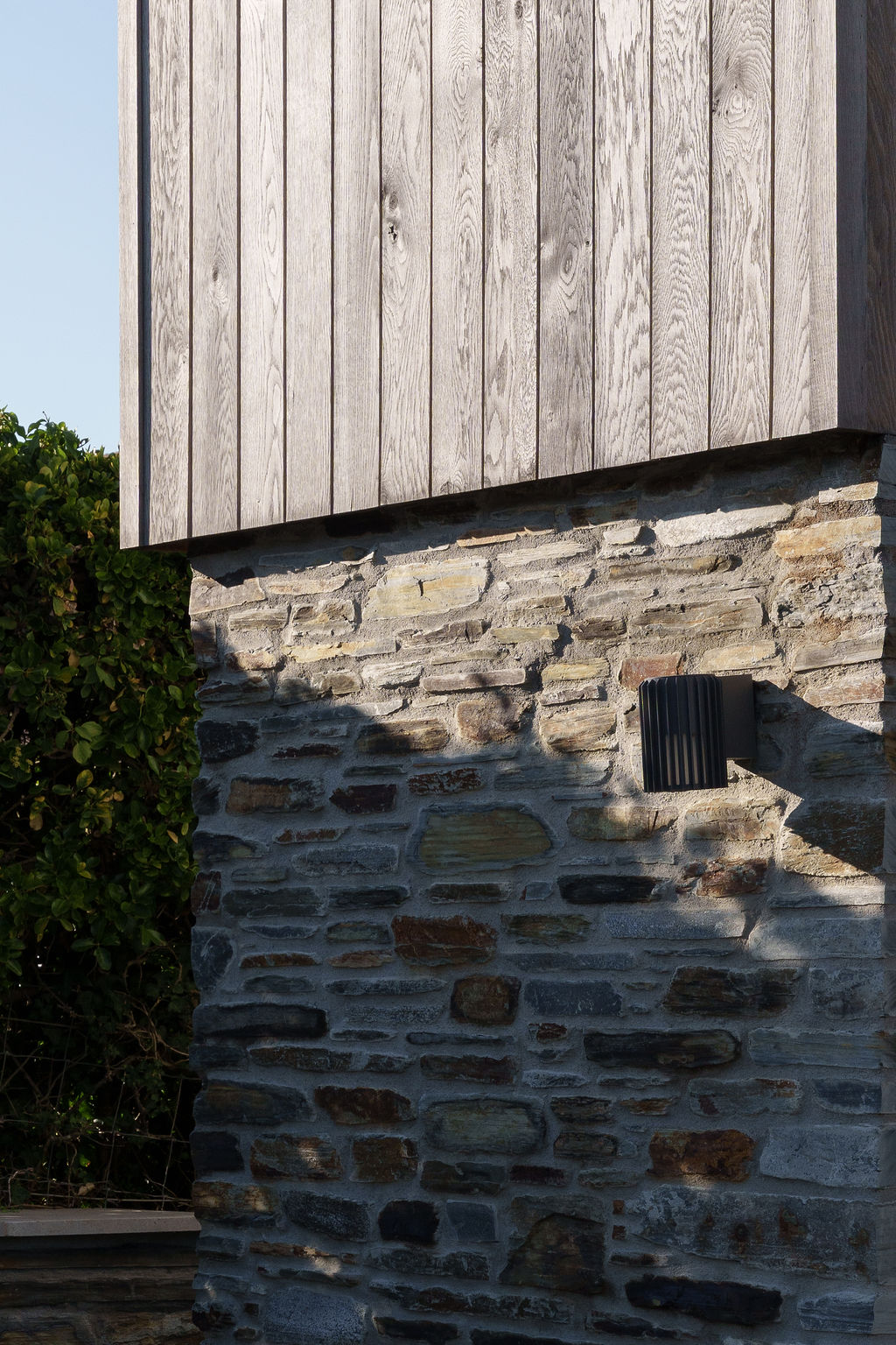 Detail of oak cladding meeting Cornish stone